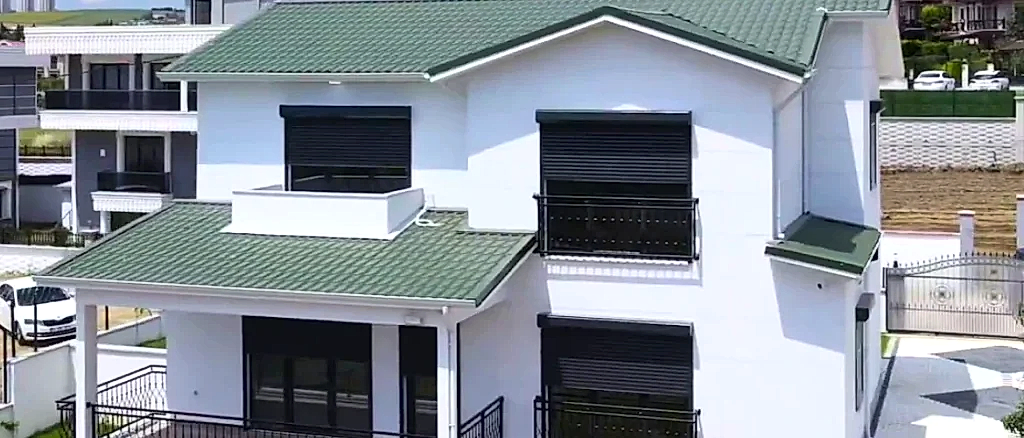 Şehir içinde balkonlu, yeşil çatılı modern çelik ev